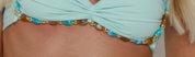 Close-up of the beaded trim on the Talisman mint bandeau bikini top, showing oval turquoise beads, marbled amber beads and round gold beads running along the underbust and the centre front twist